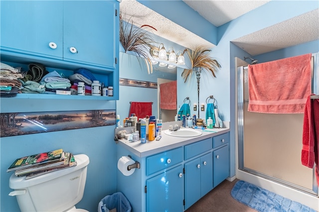 bathroom featuring a shower with door, vanity, a textured ceiling, and toilet