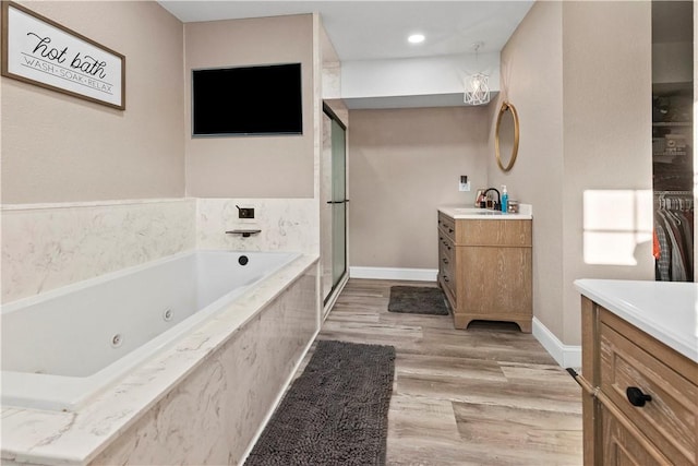 13136 Cedar Grove Rd, Lead Hill, AR 72644 - full bathroom with vanity, baseboards, a shower stall, a tub with jets, and wood finished floors