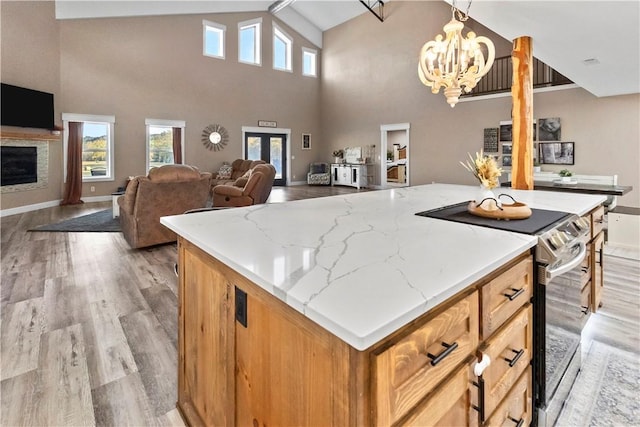 kitchen with a healthy amount of sunlight, electric range, open floor plan, and decorative light fixtures