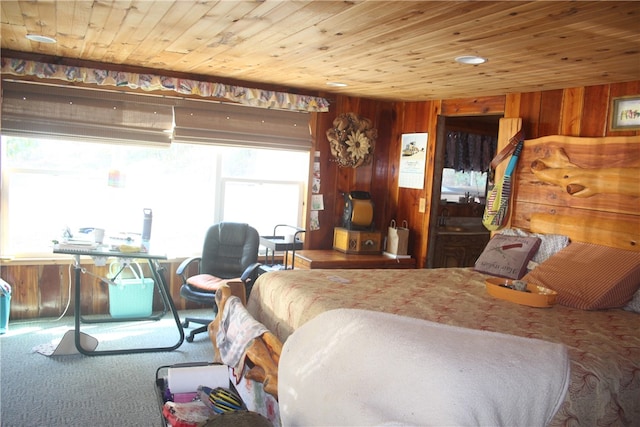 carpeted bedroom with wood ceiling and wooden walls