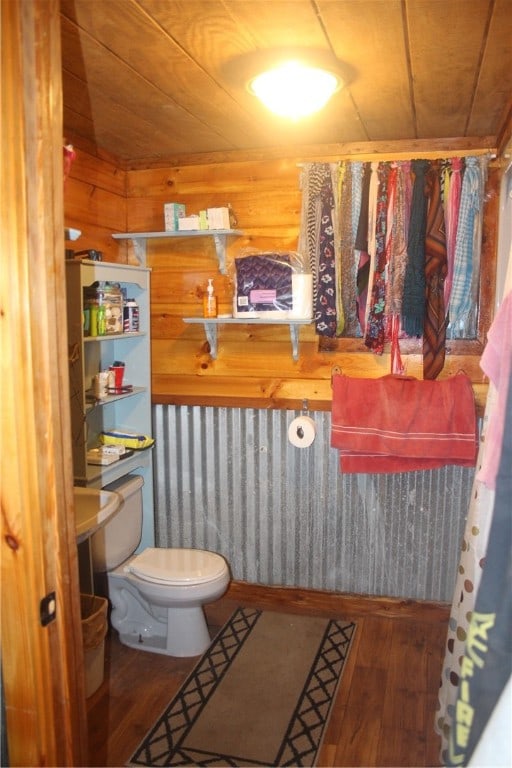 bathroom featuring toilet, wood ceiling, wooden walls, and hardwood / wood-style floors