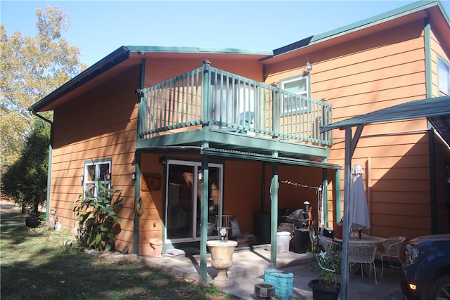 rear view of house featuring a patio and a balcony