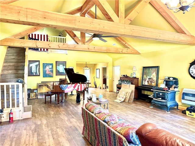 living area featuring high vaulted ceiling, heating unit, beamed ceiling, and wood finished floors