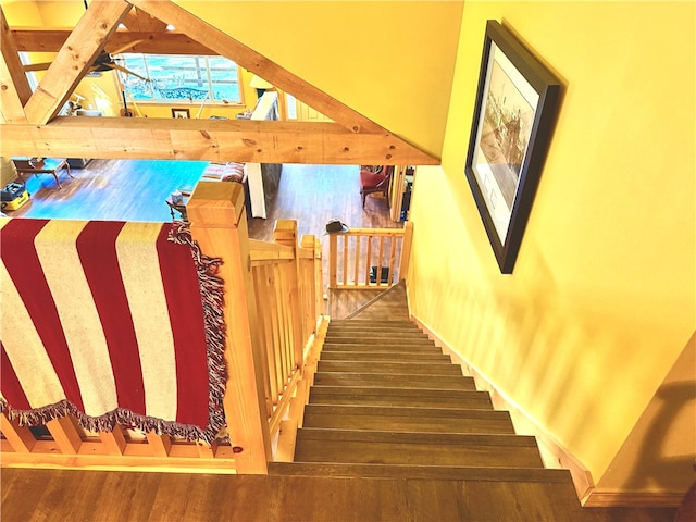 stairs featuring ceiling fan, hardwood / wood-style flooring, and a high ceiling