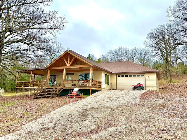 view of front of home with a porch, driveway, a garage, and a shingled roof