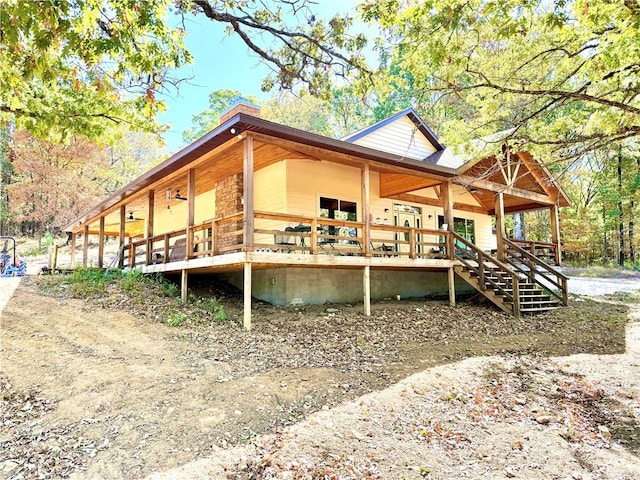 rear view of house with a chimney and a porch