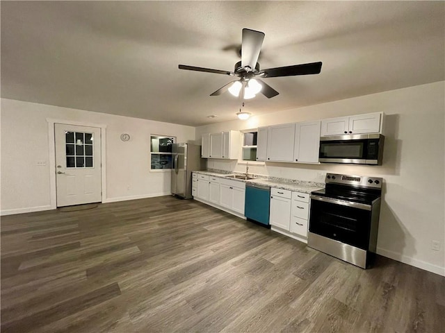 kitchen featuring appliances with stainless steel finishes, white cabinets, sink, ceiling fan, and dark hardwood / wood-style floors