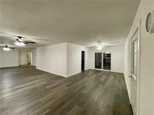 spare room featuring baseboards, dark wood-style floors, and a ceiling fan