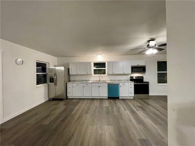 kitchen featuring dark wood-style flooring, appliances with stainless steel finishes, baseboards, and a sink