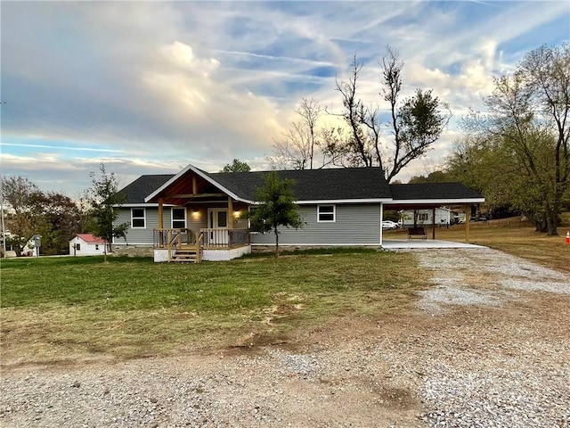 view of front of house featuring a front lawn, an attached carport, a porch, and driveway