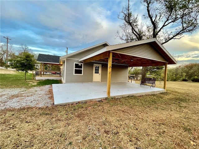 rear view of house with a patio and a lawn