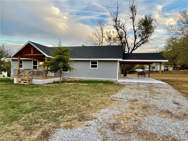 ranch-style house with covered porch, a front yard, and a carport