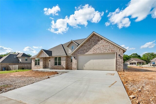 825 Baker St, Pea Ridge, AR 72751 - view of front of house featuring driveway, an attached garage, board and batten siding, and brick siding