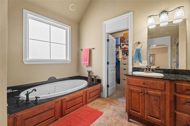 bathroom with a bath, tile patterned flooring, vanity, and vaulted ceiling