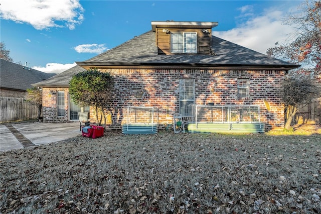 back of property with a patio area and a yard