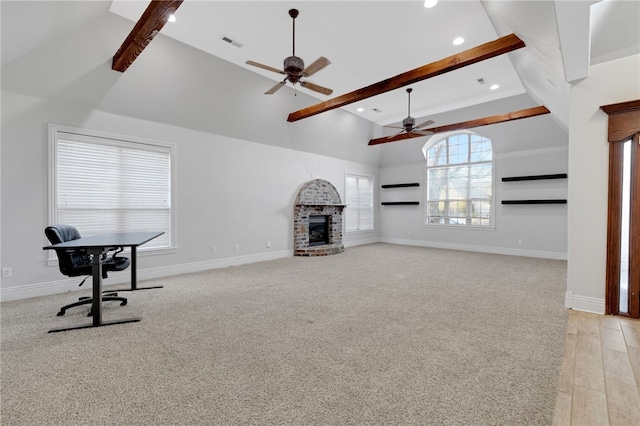 unfurnished living room featuring ceiling fan, beam ceiling, a fireplace, and high vaulted ceiling