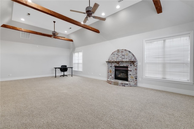 unfurnished living room featuring a fireplace, beam ceiling, carpet floors, and ceiling fan