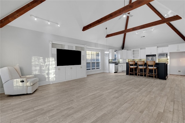 living room featuring beam ceiling, rail lighting, light hardwood / wood-style flooring, high vaulted ceiling, and ceiling fan with notable chandelier