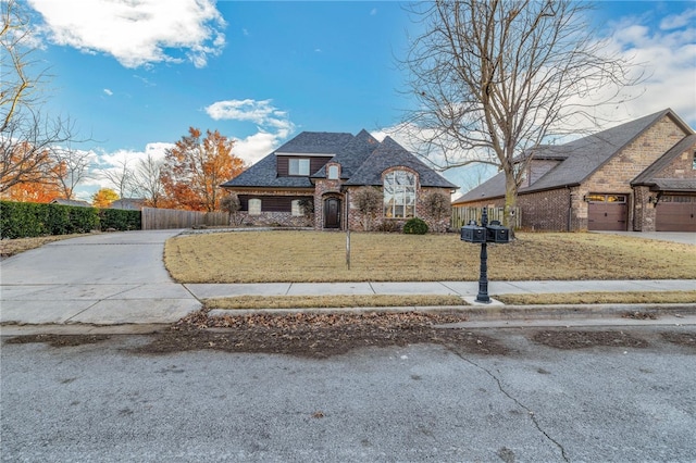 french provincial home with a garage and a front lawn