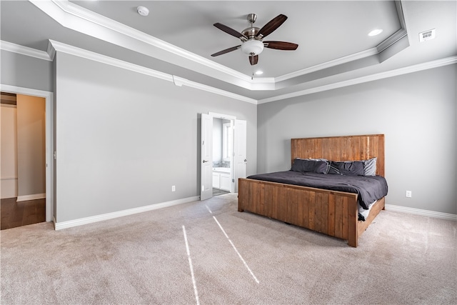 carpeted bedroom featuring crown molding, ceiling fan, ensuite bathroom, and a tray ceiling