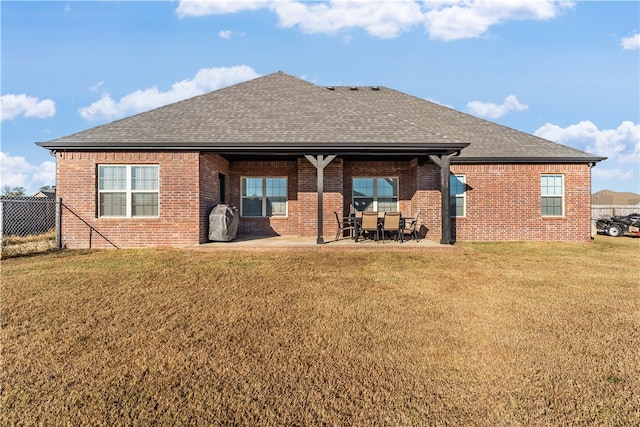 back of property with a patio and a yard