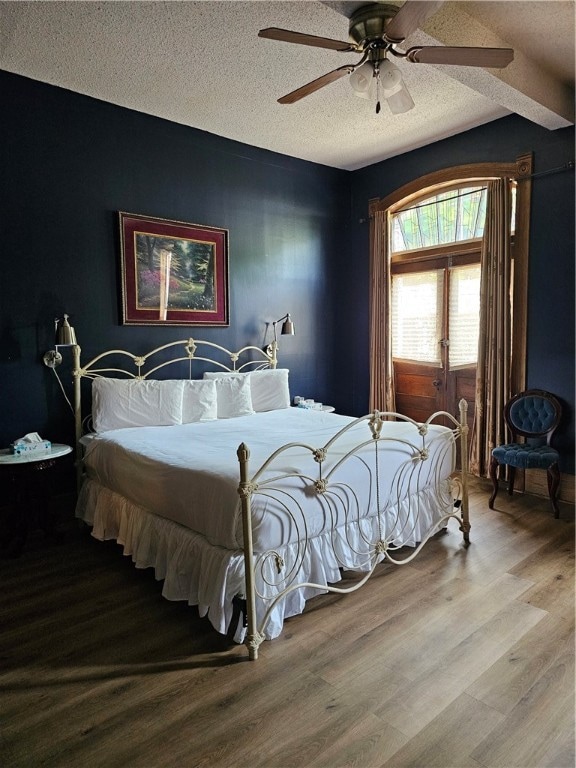 bedroom featuring a textured ceiling, wood-type flooring, and ceiling fan