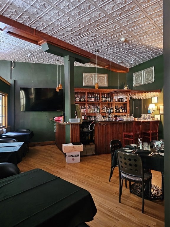 bar with brick ceiling, vaulted ceiling, and hardwood / wood-style flooring