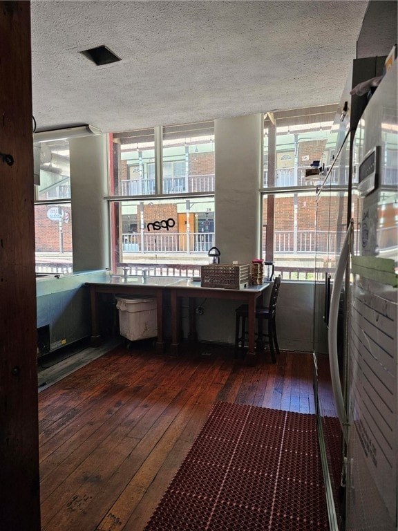 miscellaneous room featuring a textured ceiling and dark hardwood / wood-style flooring