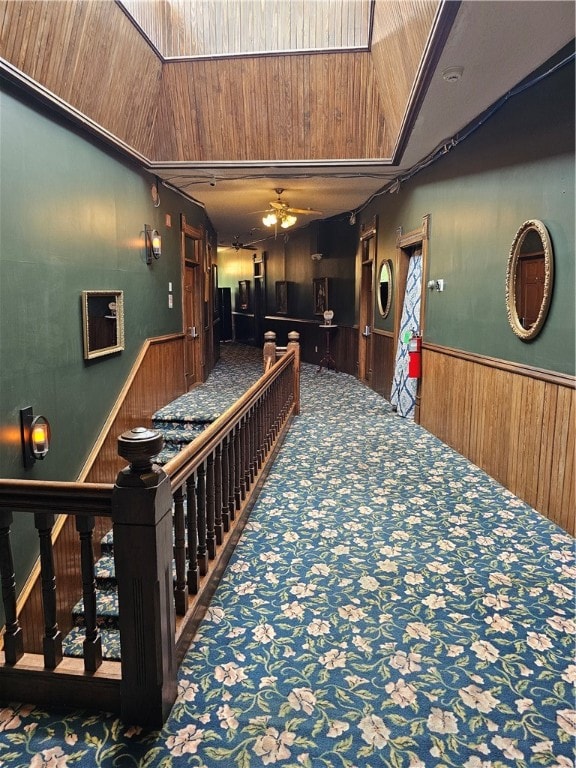 hallway with wood walls and carpet flooring