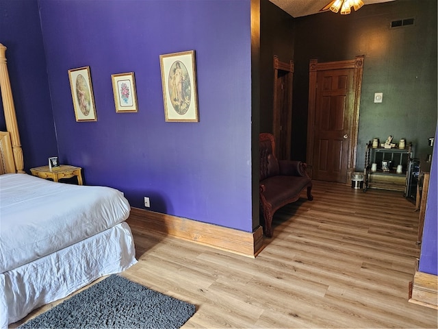 bedroom with light hardwood / wood-style floors and ceiling fan