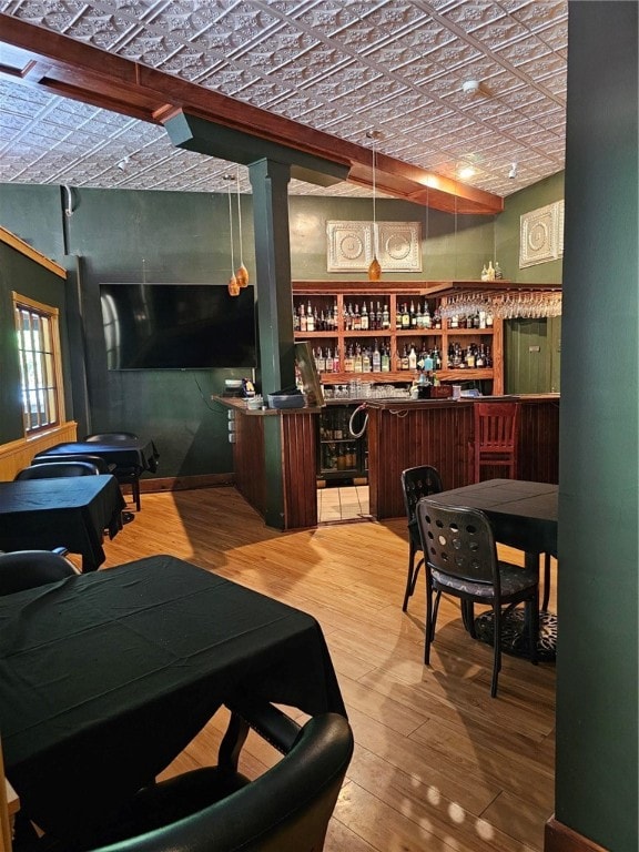 bar with brick ceiling, hardwood / wood-style floors, and lofted ceiling