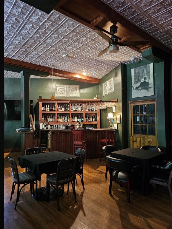 bar with lofted ceiling, hardwood / wood-style flooring, brick ceiling, and ceiling fan