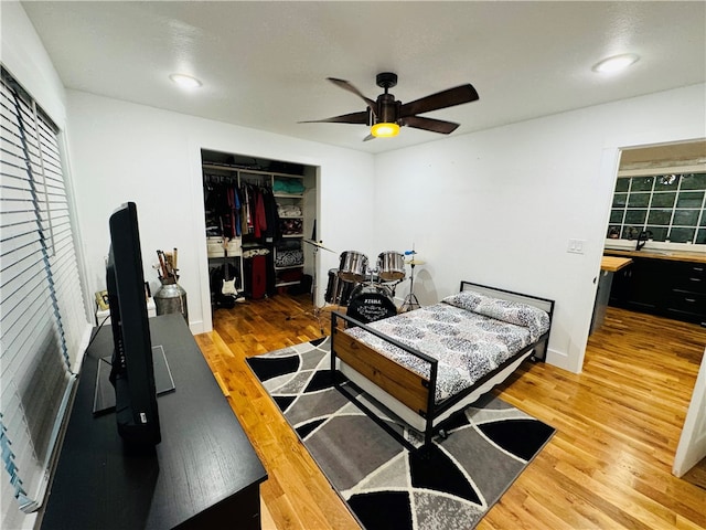 bedroom with a closet, ceiling fan, wood-type flooring, and sink