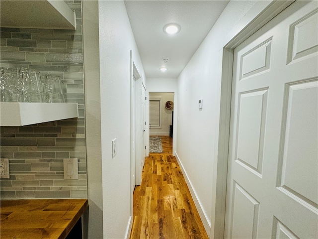 hallway with hardwood / wood-style flooring