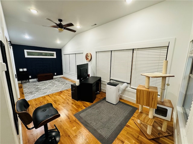 living room featuring ceiling fan, vaulted ceiling, and light wood-type flooring