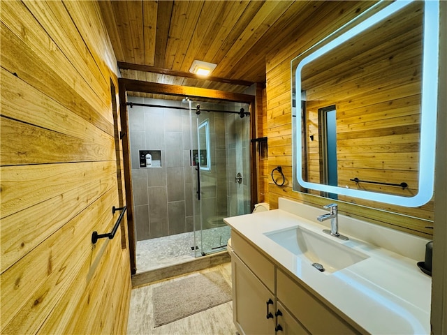 bathroom featuring hardwood / wood-style flooring, wooden ceiling, vanity, an enclosed shower, and wooden walls