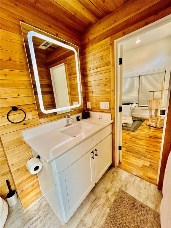 bathroom featuring vanity, wooden walls, hardwood / wood-style flooring, and wooden ceiling