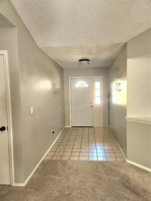 carpeted foyer with a textured ceiling