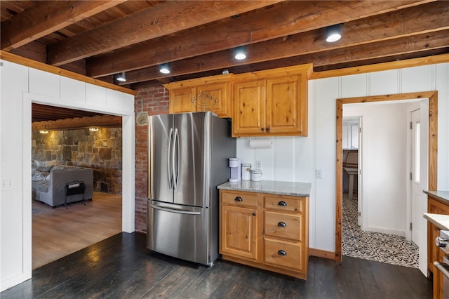 kitchen featuring dark hardwood / wood-style flooring, light stone counters, wooden ceiling, beamed ceiling, and stainless steel refrigerator