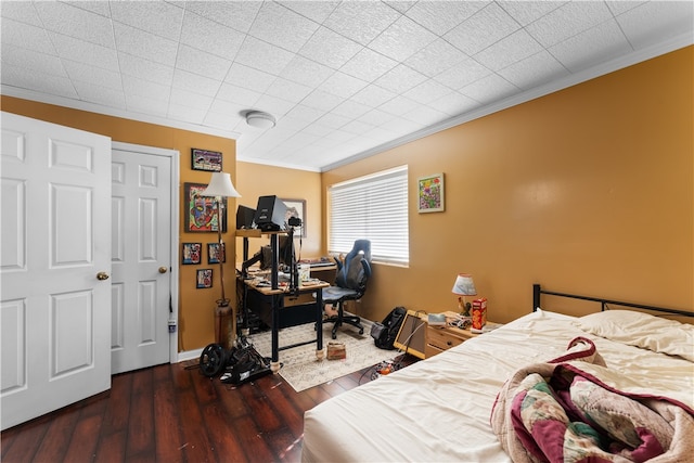 bedroom with dark wood-type flooring and ornamental molding