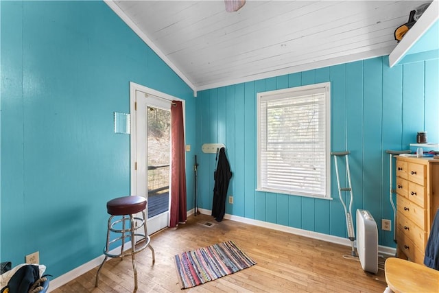 interior space featuring wood-type flooring, vaulted ceiling, and baseboards