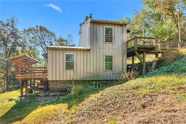 view of home's exterior featuring board and batten siding, metal roof, and a deck