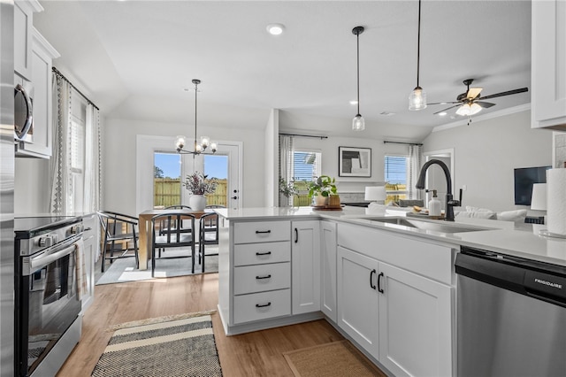 kitchen with appliances with stainless steel finishes, light hardwood / wood-style flooring, white cabinets, and a wealth of natural light