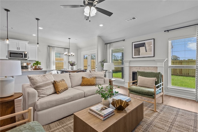 living room featuring light hardwood / wood-style flooring and ceiling fan with notable chandelier