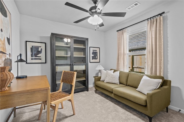 carpeted home office featuring ceiling fan