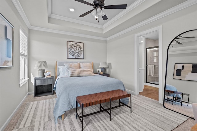 carpeted bedroom featuring connected bathroom, ceiling fan, crown molding, and a raised ceiling