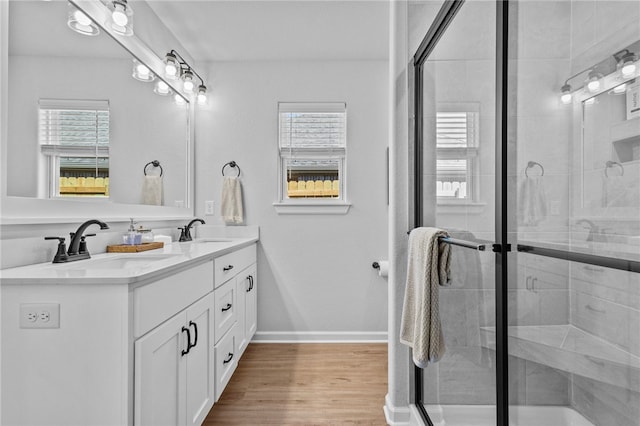 bathroom featuring vanity, wood-type flooring, a wealth of natural light, and walk in shower