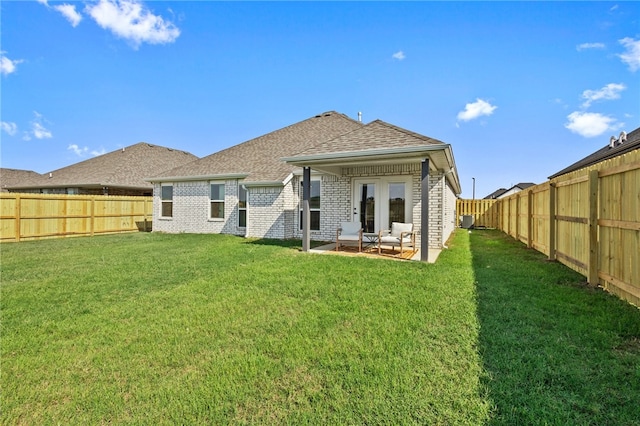 back of property with a yard and a patio area