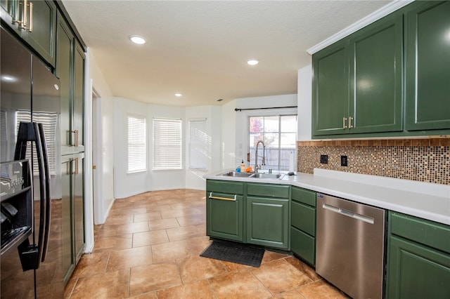 kitchen featuring decorative backsplash, appliances with stainless steel finishes, green cabinets, and sink