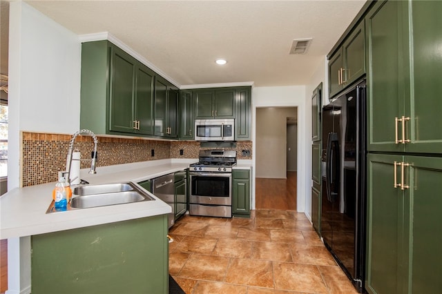 kitchen featuring tasteful backsplash, sink, stainless steel appliances, and green cabinetry